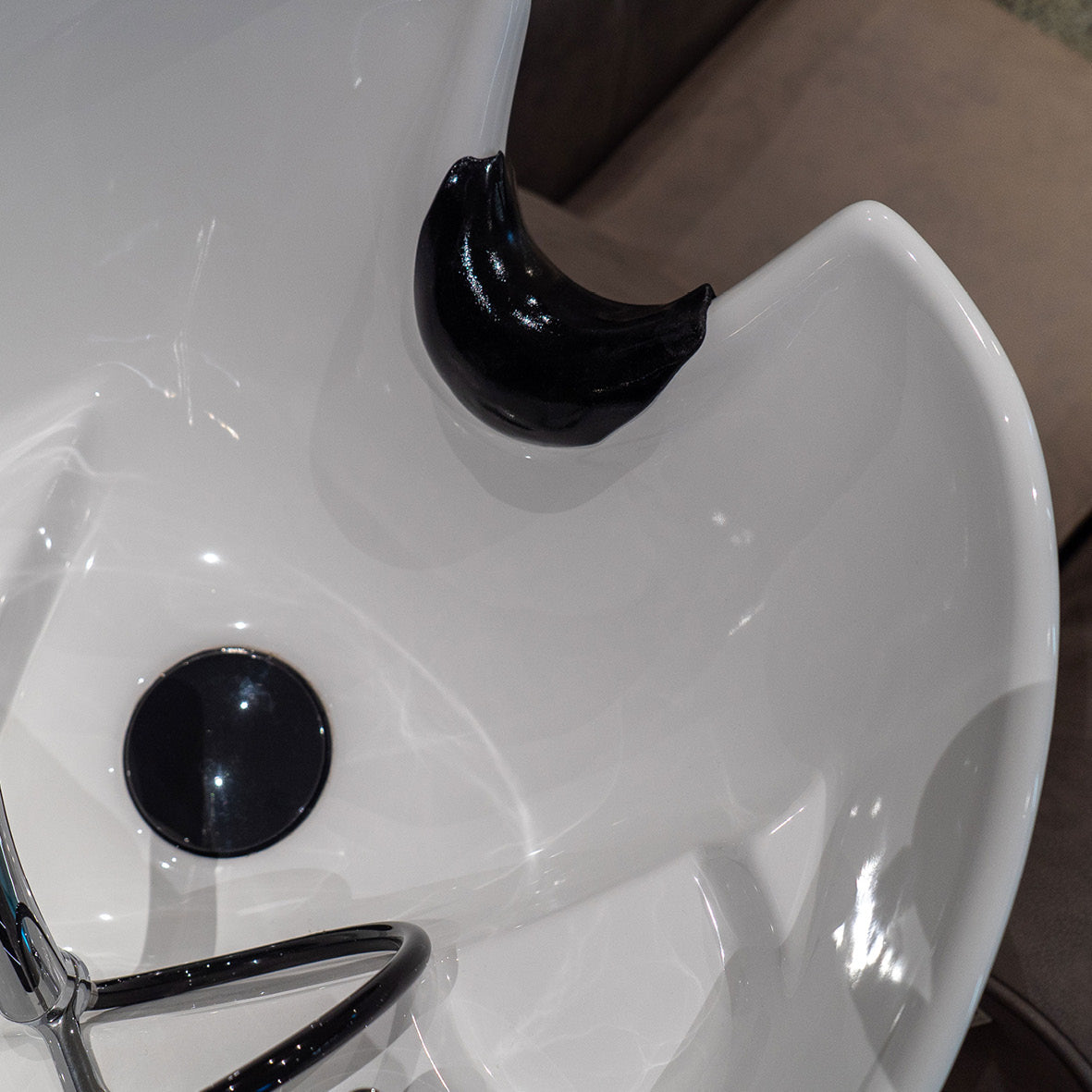 Musta niskapehmuste kampaamon pesupaikkaan